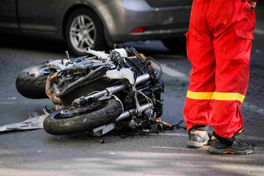 Man in hi-viz next to a motorcycle crash