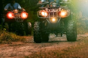 Two ATVs with lights on 