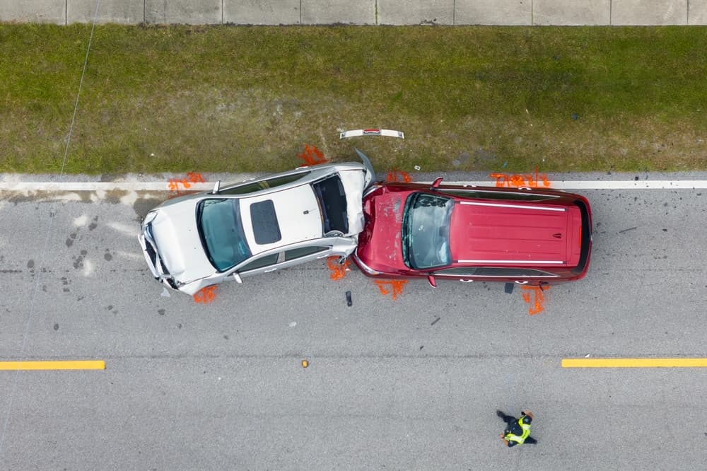 An aerial view of a car damaged by a collision with another vehicle.