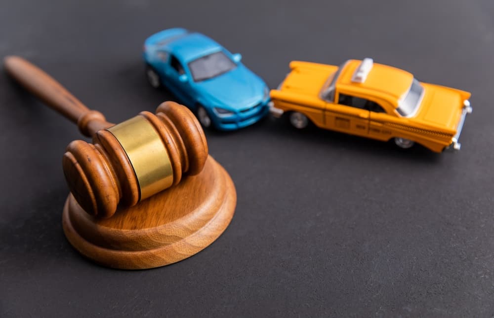 Judge's gavel with two cars colliding in a traffic accident.