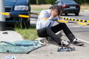 A sad man at the scene of a road accident, captured horizontally. 