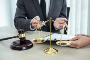 Male lawyer discussing a legal case negotiation with a client, reviewing contract documents in the office. Concept of law, justice, attorney, and lawsuit.