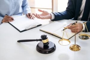 A businesswoman and a male lawyer or judge are consulting during a team meeting with a client at a law firm office, representing the concept of law and legal services.