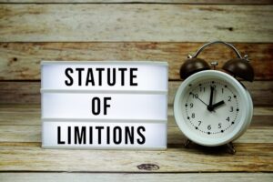 "LED Lightbox Displaying Statute of Limitations Text Next to an Alarm Clock on a Wooden Background." 