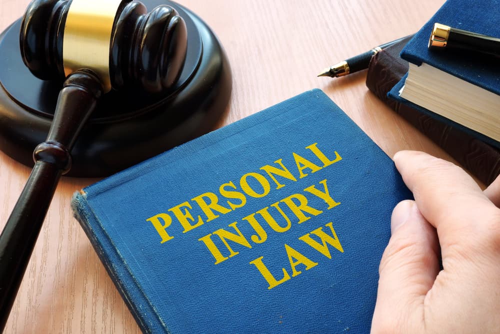 Personal injury law book and a gavel resting on a desk.