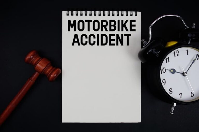 Motorbike accident lawsuit timeline concept with gavel, clock, and notebook illustrating the duration and legal process after a motorcycle crash.