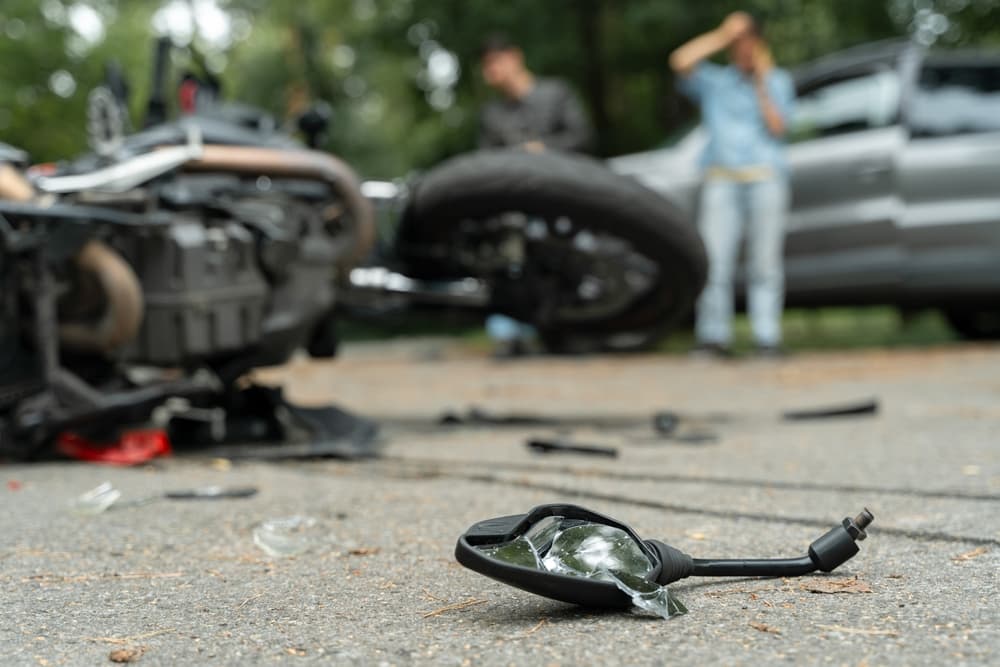 Motorcycle accident scene in Kentucky showing a damaged bike and debris on the road, highlighting the urgent steps victims should take afterward.